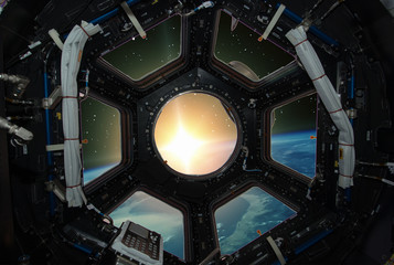 Fascinating sunrise on earth. Spaceship window view. Elements of this image furnished by NASA.