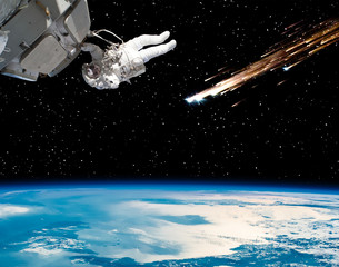 Astronaut holding for the spaceship and meteor rain. The elements of this image furnished by NASA.