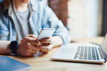 Young man works on the laptop in the cafe.