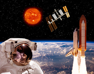 Astronaut looks at the space station. The elements of this image furnished by NASA.