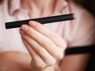 Woman's beauty blogger hands holding sample tone pencil box professional hi-end cosmetics with...