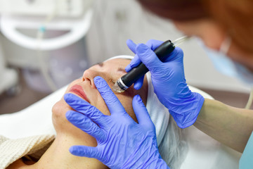 Skin care. Woman receiving facial beauty treatment. Facial therapy. Anti-aging procedures.