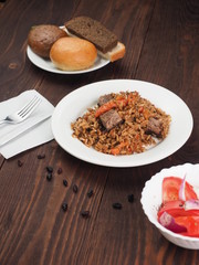 Rice with Vegetables and Meat in a plate on wooden table