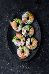 Sushi donuts on plate on dark background. Top view.