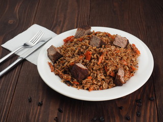 Rice with Vegetables and Meat in a plate on wooden table