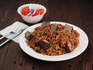 Rice with Vegetables and Meat in a plate on wooden table