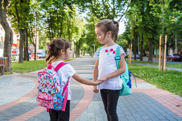 Back to school education concept with girl kids, elementary students, carrying backpacks going to class