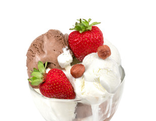 Vanilla ice cream with almonds and strawberries. Creamy vanilla ice cream with almonds, fresh strawberries and mint leaves in a crystal bowl on a white background