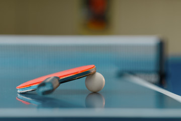 Ping pong racket and ball on game table, closeup