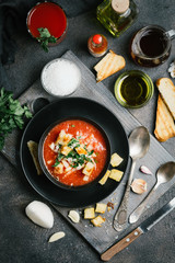 Traditional spanish gazpacho made from fresh farm produce on a dark background. top view