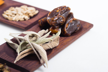 dried fruits and spices on wooden tray, white table