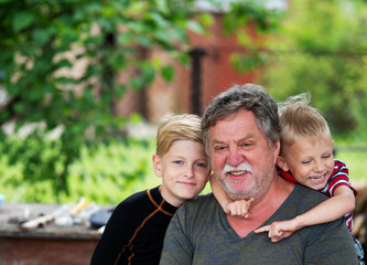 Portrait of a middle-aged Caucasian gray-haired man with a grandsons