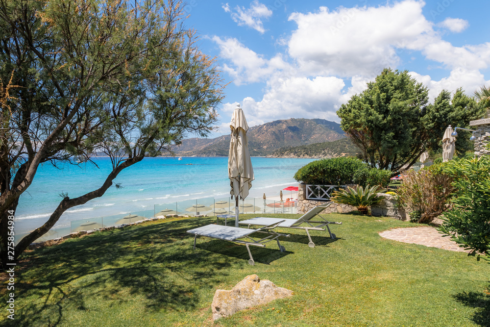 Wall mural Holidays in Sardinia, Italy. View of sandy beach and sea with azure turquoise crystal clear water, mountains in the background, near Villasimius, Cagliary region. The best beaches in Sardinia. - Wall murals