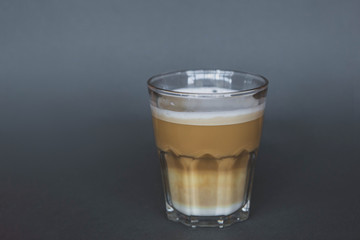 large transparent glass filled with of aromatic coffee photographed on the isolated gray background picture for the menu.