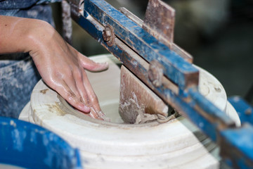 hands of a potter, creating an bowl using a terraja, Pottery polishing process with 2 hands in the final step. Before entering the kiln..