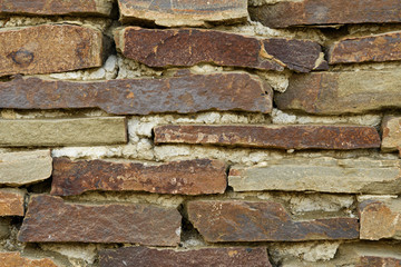 The wall is made of large stone fragments connected directly to each other with the help of concrete cement mixture