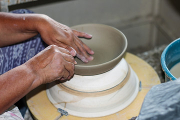 hands of a potter, creating an bowl on the circle, Pottery polishing process with 2 hands in the final step. Before entering the kiln.
