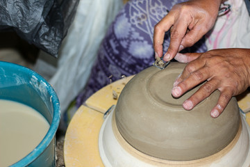 hands of a potter, creating an bowl on the circle, Pottery polishing process with 2 hands in the final step. Before entering the kiln.