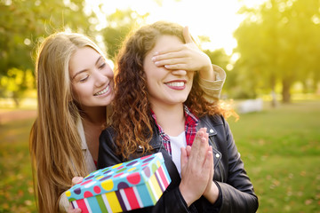 Beautiful young women gives a birthday gift to her friend