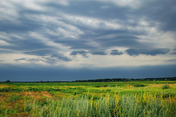 Obraz premium Dark rain storm clouds over the field