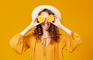 cheerful young curly woman girl with   orange   on  yellow   background