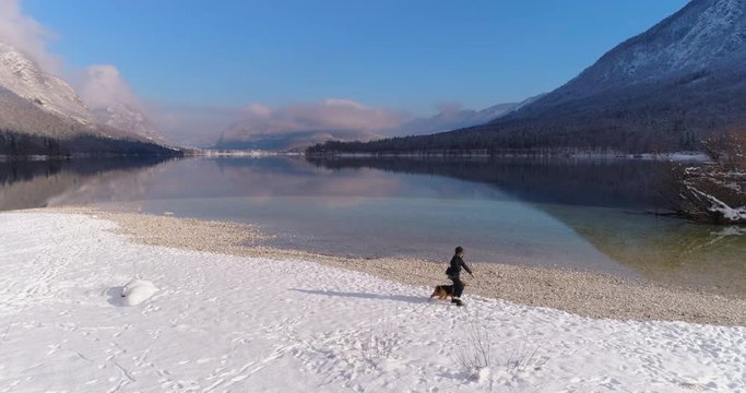 Woman playing with her Airedale Terrier dog in snow