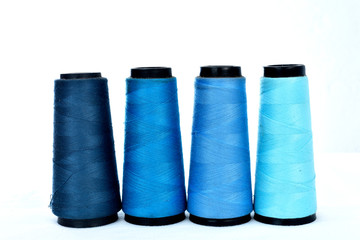 Colorful sewing thread reels on white background
