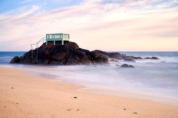View point or gazebo over the rocks on a beach in Vila do Conde, Portugal, at sunset.