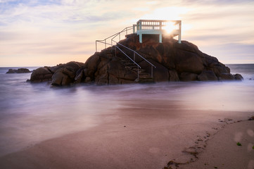 View point or gazebo over the rocks on a beach in Vila do Conde, Portugal, at sunset.