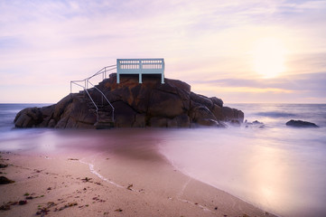View point or gazebo over the rocks on a beach in Vila do Conde, Portugal, at sunset.