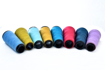 Colorful sewing thread reels on white background