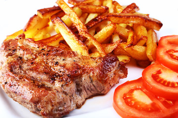 Grilled free-range beef steak with potato free, fresh tomatoes and sauce on a brown stone background