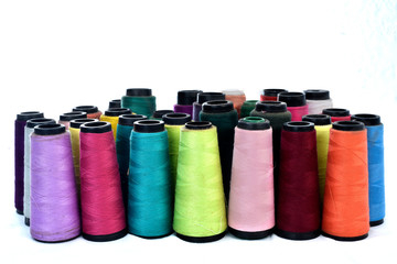Colorful sewing thread reels on white background