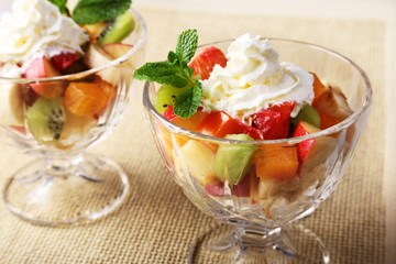 Diet-Fresh tasty mix fruit salad in the bowl on the wooden table, healthy breakfast, weight loss concept.