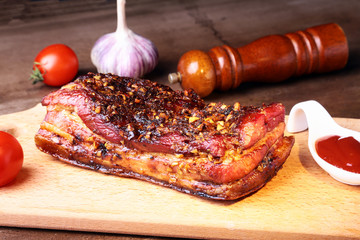 Grilled pork ribs barbecue Striploin steak with chimichurri sauce and tomatoes on cutting board on dark background.