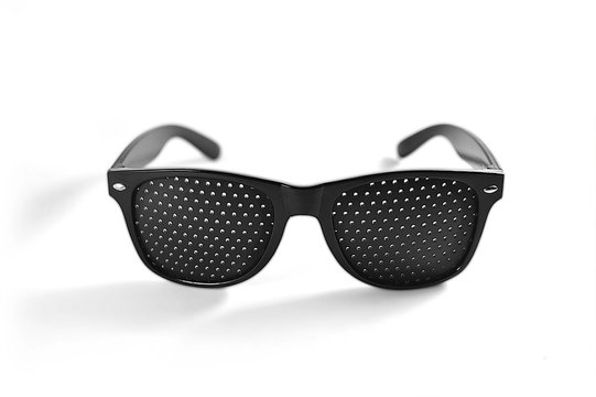 Black perforated glasses medical spectacles with hole on white background. Perforated glasses, glasses with holes for vision, pinhole glasses.