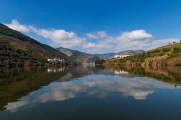 Naklejka na ściany i meble Scenic view of the Pinhao village with terraced vineyards and the Douro River and the Douro Valley, in Portugal; Concept for travel in Portugal and most beautiful places in Portugal