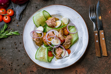 Tuna and vegetable salad on dark concrete rustic background