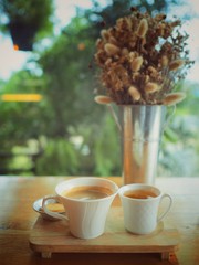 cup of tea and flowers on wooden table