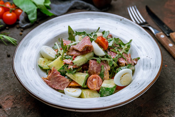 Salad with roast beef and eggs on dark concrete rustic background