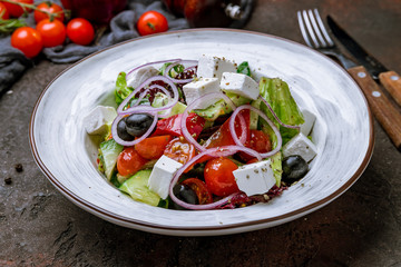 Greek salad with feta on dark concrete rustic background