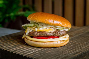 Burger with meat and cheese on the board