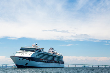 Fototapeta na wymiar A Massive Luxury Blue and White Cruise Ship by Bridge in Rhode Island
