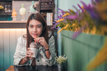 Asian woman drinking coffee in a cafe.