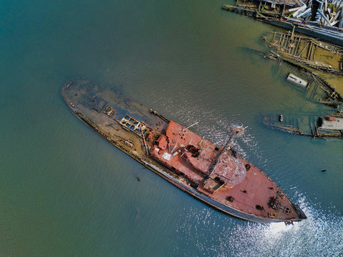 Aerial drone image of Sunken and rotting Wood ships and rotting hulls and rusting  Iron ships with some leaking chemicals and oil into the local creek in Staten Island New York
