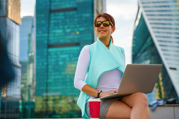 Portrait of business woman sitting with laptop and cup of coffee