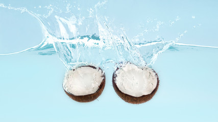 Coconut halves sinking deeply in clear water