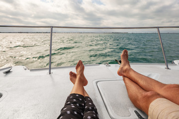 Yacht boat lifestyle couple relaxing on cruise ship in Hawaii holiday . Two tourists feet relax...