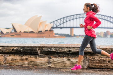 Obraz premium Biegaczka pasuje do kobiety uprawiającej aktywny styl życia, uprawiającej jogging w Sydney Harbour przy słynnej atrakcji turystycznej Opery. Życie w mieście.
