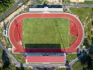 Aerial top view on a soccer field, grandstand, football field with red running track. race track in a stadium.